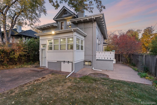 view of front of house with a patio area and a lawn