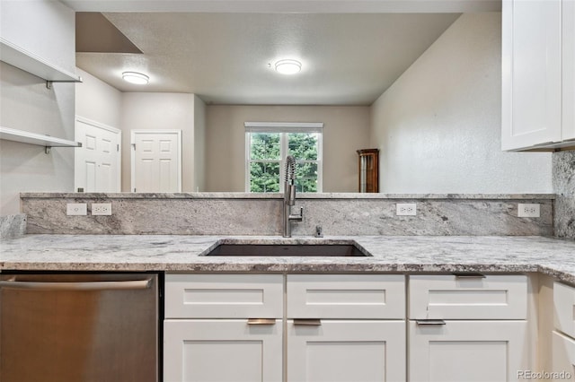 kitchen featuring light stone counters, a sink, white cabinetry, dishwasher, and open shelves