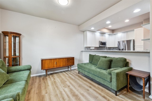 living room featuring light wood-style floors, recessed lighting, and baseboards