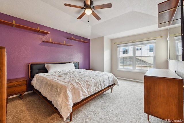 bedroom with a textured wall, a ceiling fan, baseboards, vaulted ceiling, and carpet