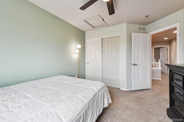 bedroom with carpet, a closet, visible vents, attic access, and a ceiling fan