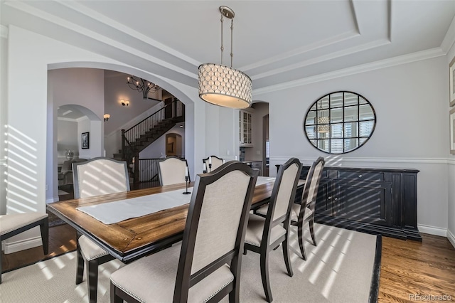 dining area featuring crown molding, hardwood / wood-style floors, and a tray ceiling