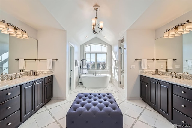 bathroom featuring vaulted ceiling, shower with separate bathtub, vanity, and an inviting chandelier