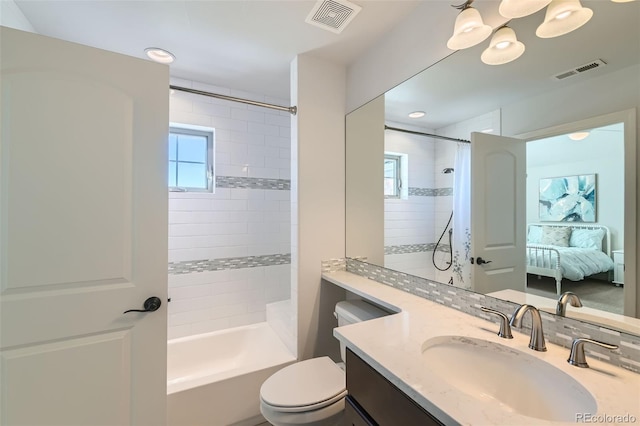 full bathroom with tiled shower / bath combo, vanity, and toilet