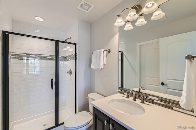 bathroom with vanity, toilet, and a shower with shower door