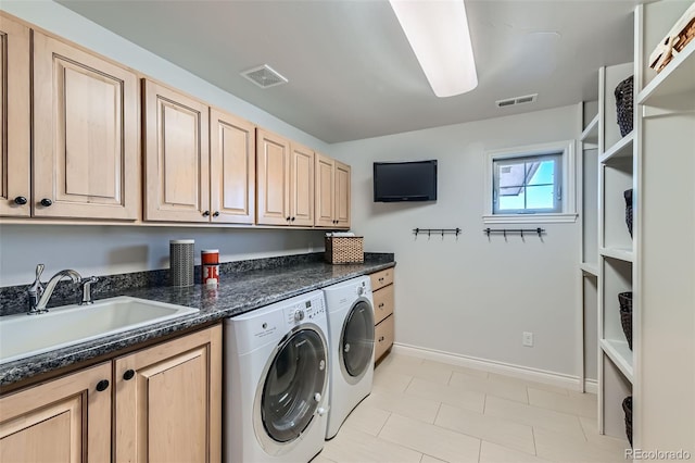 laundry room featuring independent washer and dryer, sink, and cabinets