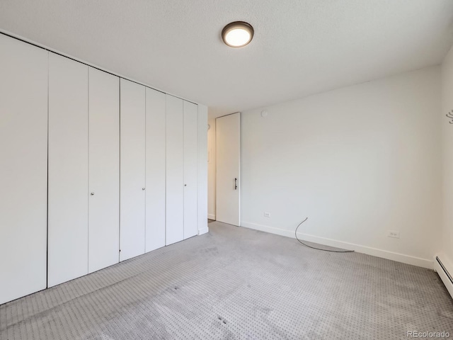 unfurnished bedroom featuring light colored carpet and a textured ceiling