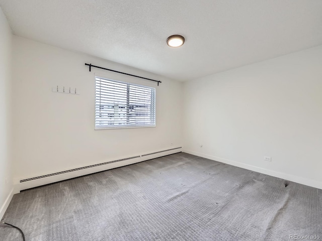 carpeted spare room featuring a textured ceiling and baseboard heating