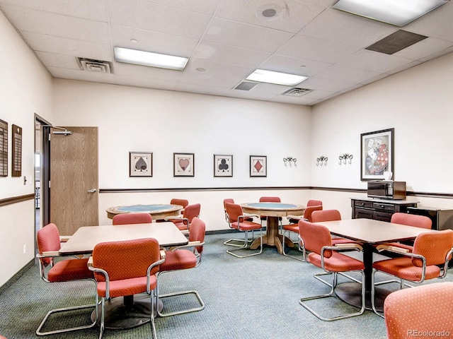 interior space featuring carpet flooring and a drop ceiling