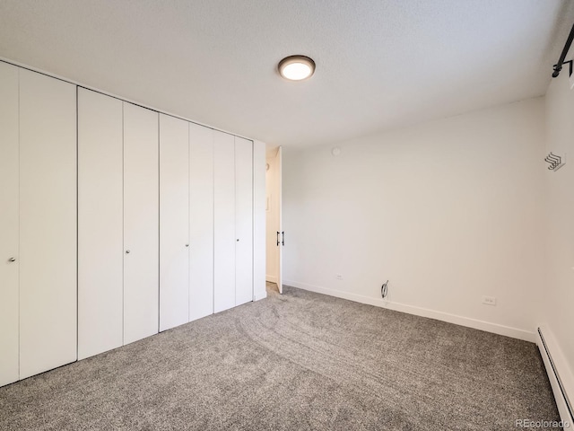 750 S Clinton St Unit 2C, Denver, CO 80247 - unfurnished bedroom featuring baseboard heating, carpet floors, baseboards, and a closet