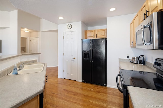 kitchen featuring recessed lighting, light wood-style flooring, light brown cabinets, a sink, and black appliances