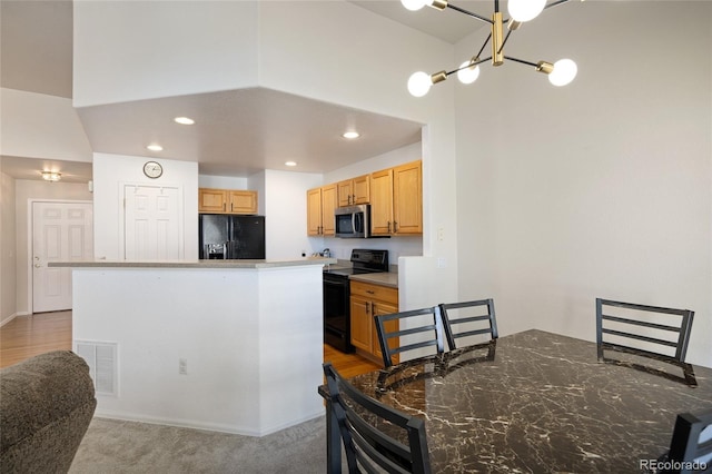 kitchen featuring black appliances, recessed lighting, visible vents, and a center island