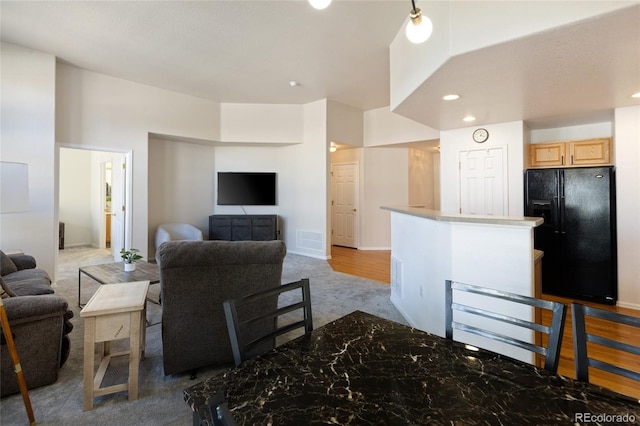 living area with recessed lighting, visible vents, and light carpet