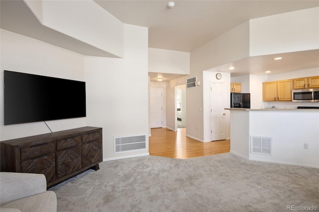 unfurnished living room featuring light colored carpet, visible vents, and recessed lighting