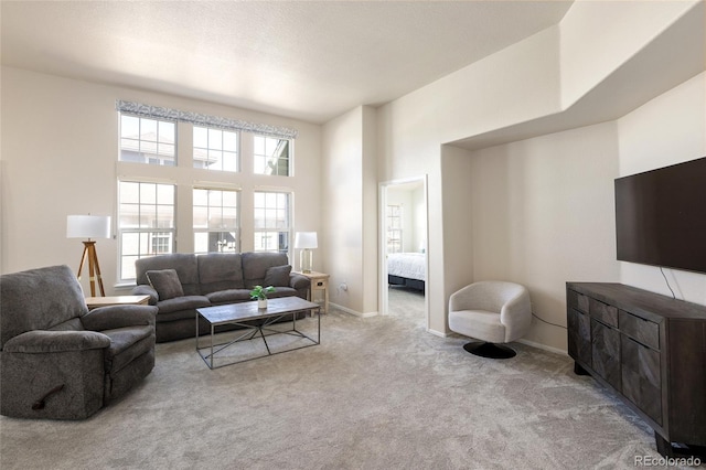 living room with carpet flooring, a textured ceiling, and baseboards