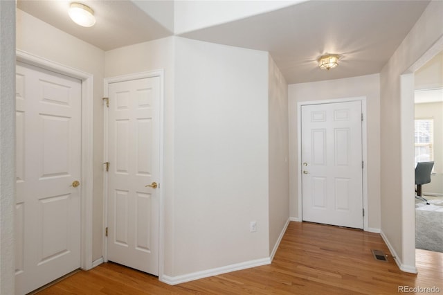 entrance foyer featuring light wood-type flooring, visible vents, and baseboards