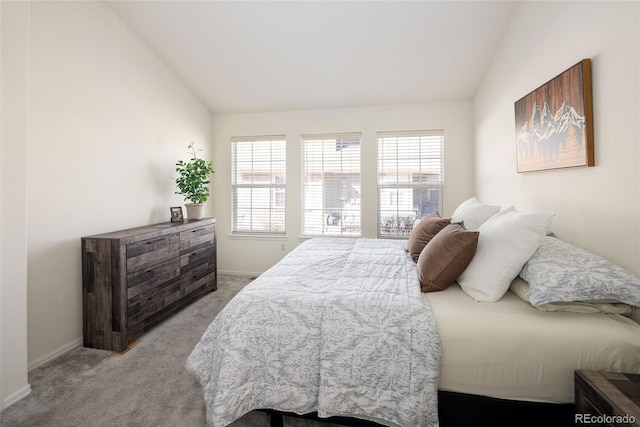 bedroom featuring lofted ceiling, baseboards, and light colored carpet