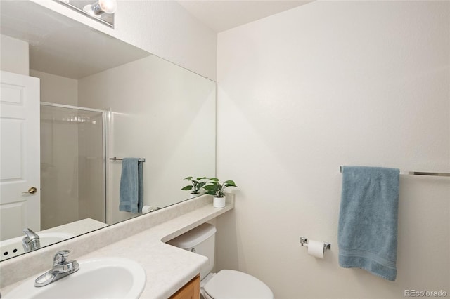 full bathroom featuring a shower with shower door, vanity, and toilet