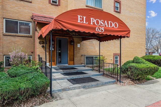 view of exterior entry featuring brick siding