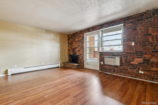 unfurnished living room with a wall mounted AC, a baseboard radiator, wood finished floors, and a textured ceiling