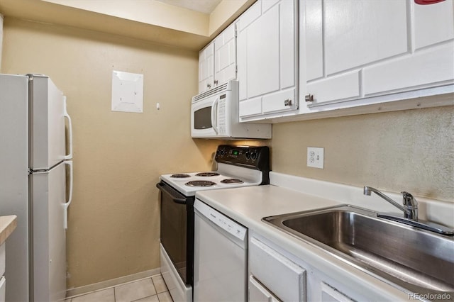 kitchen with white appliances, white cabinets, light tile patterned flooring, light countertops, and a sink