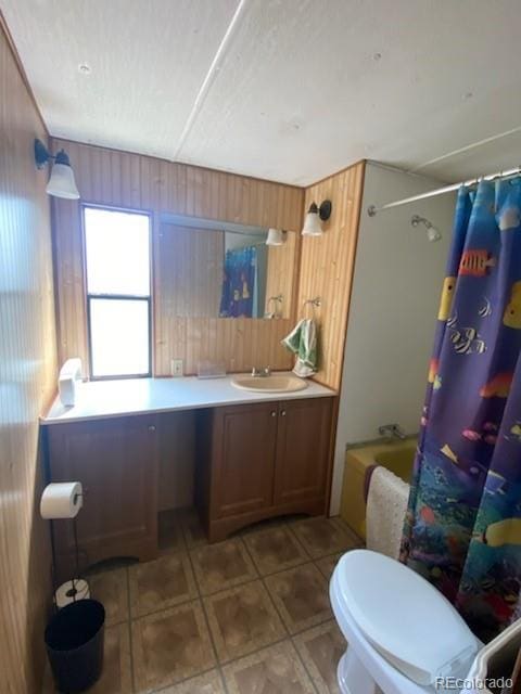 full bathroom with toilet, vanity, shower / tub combo with curtain, and wooden walls