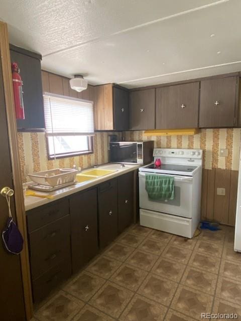 kitchen featuring dark brown cabinetry, sink, a textured ceiling, and white electric stove