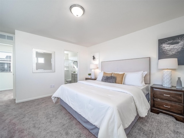 bedroom featuring light colored carpet and connected bathroom