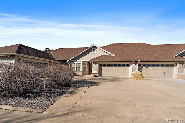 view of front of property with a garage, concrete driveway, and roof with shingles