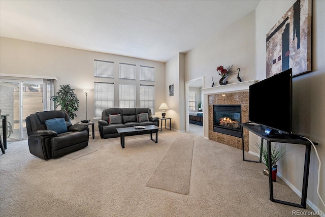 carpeted living room with a wealth of natural light, a tiled fireplace, and baseboards