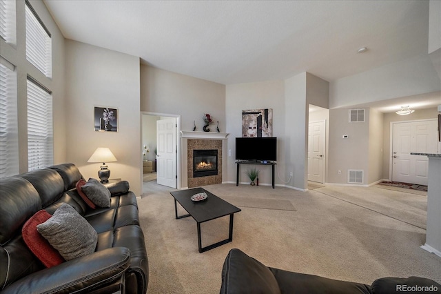 living area featuring light carpet, baseboards, a fireplace, and visible vents