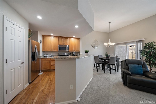 kitchen featuring stainless steel appliances, recessed lighting, hanging light fixtures, open floor plan, and a chandelier