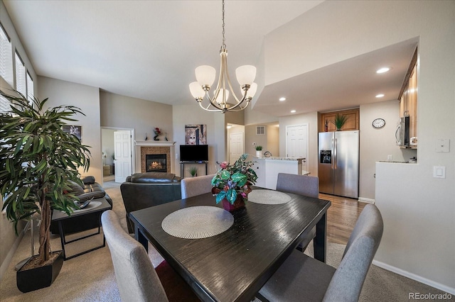 dining room featuring visible vents, baseboards, a tile fireplace, a notable chandelier, and recessed lighting