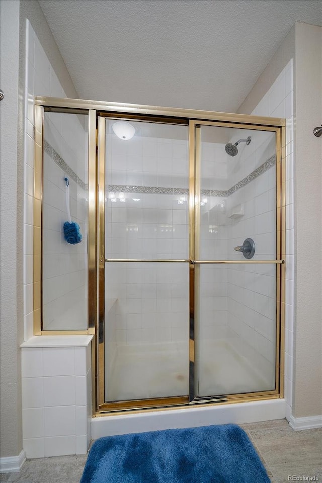 full bathroom with a tile shower and a textured ceiling