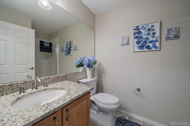 full bath with toilet, visible vents, vanity, baseboards, and a shower stall