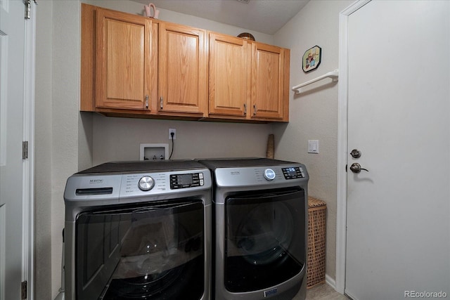 laundry area with cabinet space and washing machine and clothes dryer