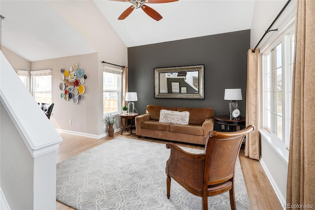 living area featuring lofted ceiling, light wood-style floors, and a healthy amount of sunlight