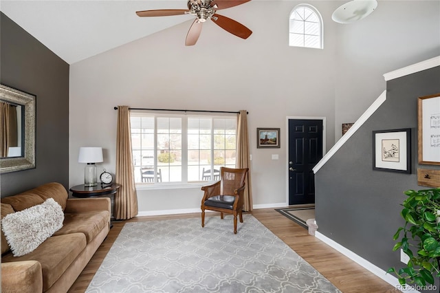 living room featuring wood finished floors, baseboards, a wealth of natural light, and high vaulted ceiling