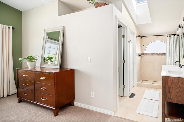 full bath featuring vanity, visible vents, baseboards, tiled shower, and vaulted ceiling