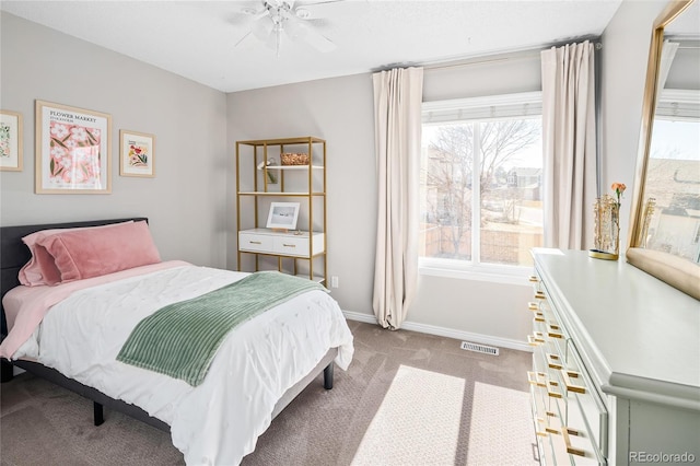 carpeted bedroom with visible vents, baseboards, and ceiling fan