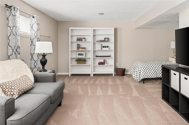 living area with light carpet, a textured ceiling, and baseboards