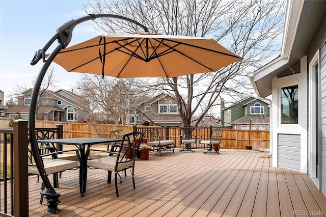 deck featuring outdoor dining space, fence, and a residential view