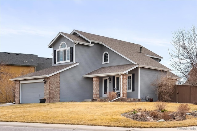 traditional-style home featuring brick siding, a porch, a shingled roof, and a front yard