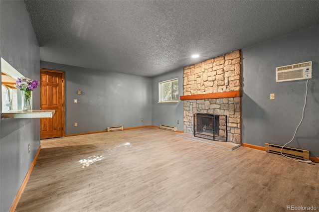 unfurnished living room featuring hardwood / wood-style flooring, a textured ceiling, a wall mounted AC, and a baseboard radiator