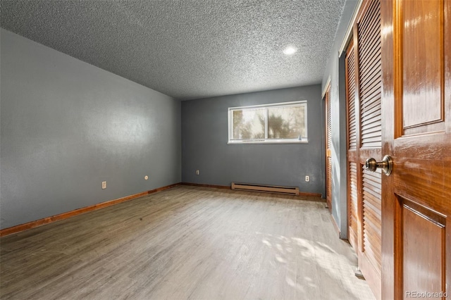 unfurnished room featuring a textured ceiling, light wood-type flooring, and a baseboard radiator