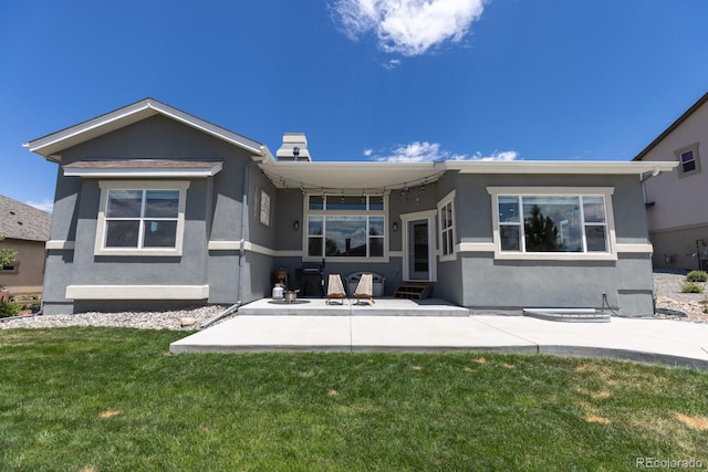 1849 Mud Hen Dr, Colorado Springs, CO 80921 - rear view of house with a lawn, entry steps, stucco siding, and a patio area
