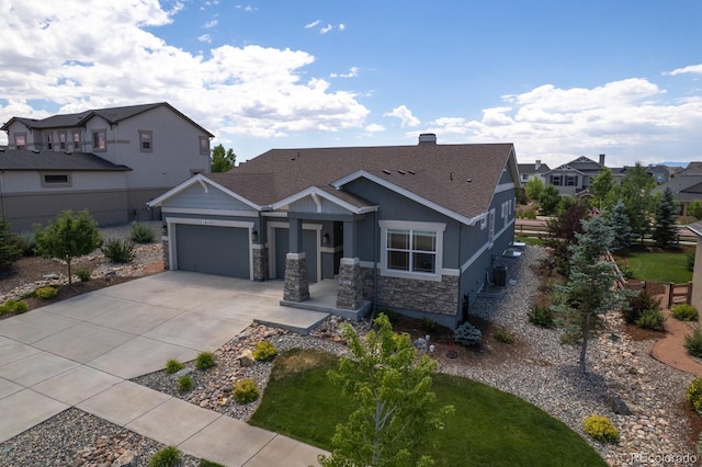 1849 Mud Hen Dr, Colorado Springs, CO 80921 - view of front facade with a garage, concrete driveway, stone siding, a shingled roof, and a residential view