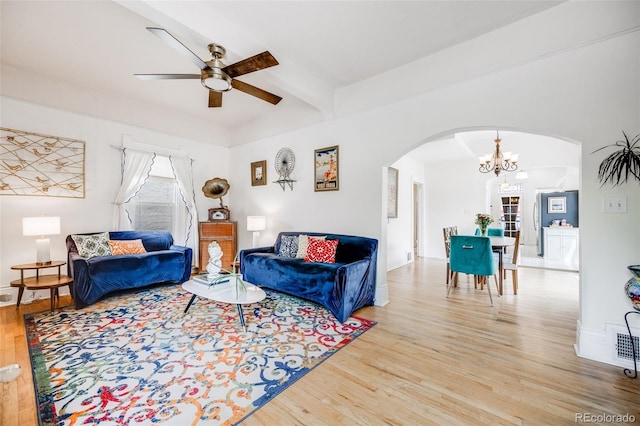 3106 N Franklin St, Denver, CO 80205 - living area featuring arched walkways, wood finished floors, ceiling fan, a chandelier, and beamed ceiling
