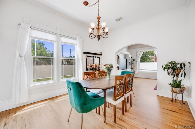3106 N Franklin St, Denver, CO 80205 - dining area featuring a chandelier, arched walkways, light wood-style flooring, and ornamental molding