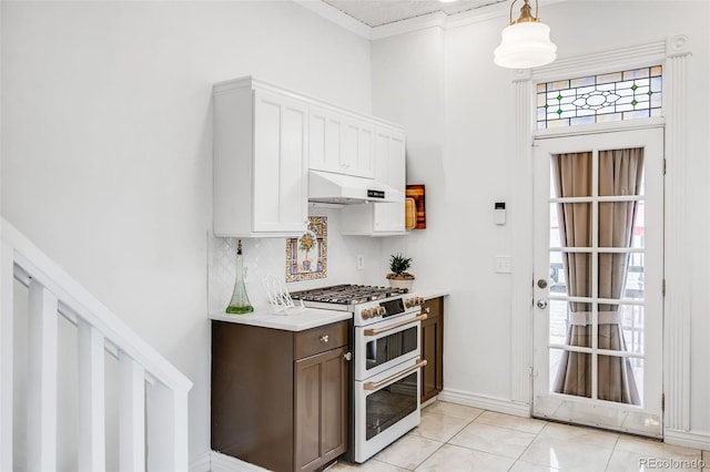 3106 N Franklin St, Denver, CO 80205 - kitchen featuring range with two ovens, under cabinet range hood, light countertops, tasteful backsplash, and ornamental molding